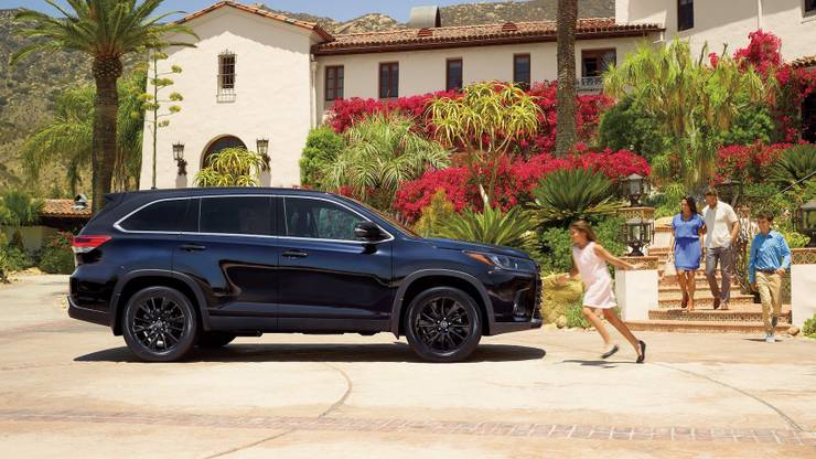 Famiglia a piedi da casa per arrivare in una Toyota Highlander